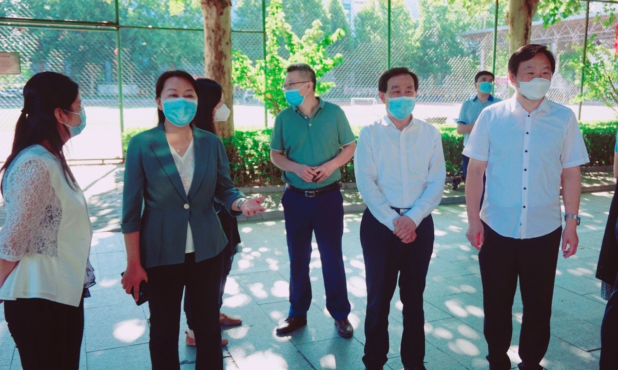 林荫路主干道上搭起的一排红色棚子的报